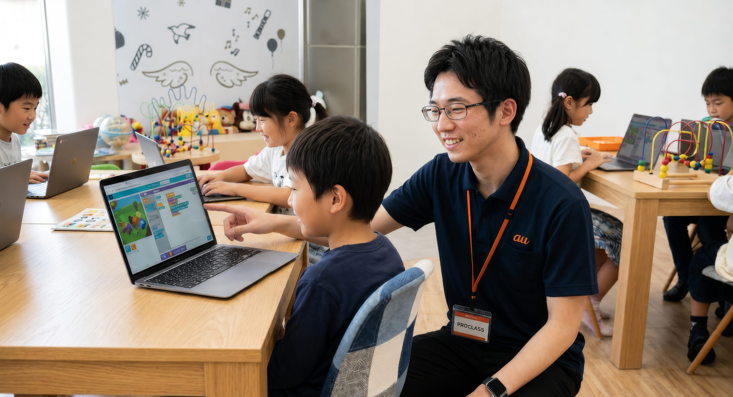 プロクラ プログラミング教室で子どもたちにパソコン操作を教えるauスタッフ